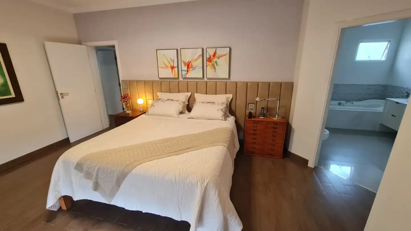 Quarto de casal com cabeceira estofada e criados-mudos